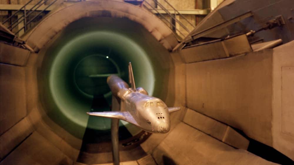 Silver space shuttle scale model in the test section of a scale wind tunnel